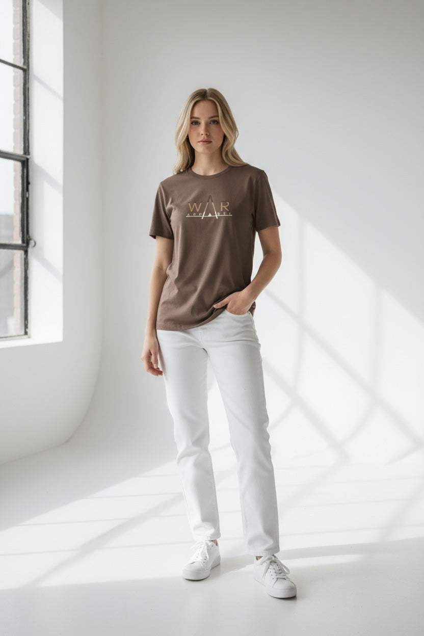 Woman wearing a brown t-shirt with 'WAR APPAREL' logo  and white pants in a bright room